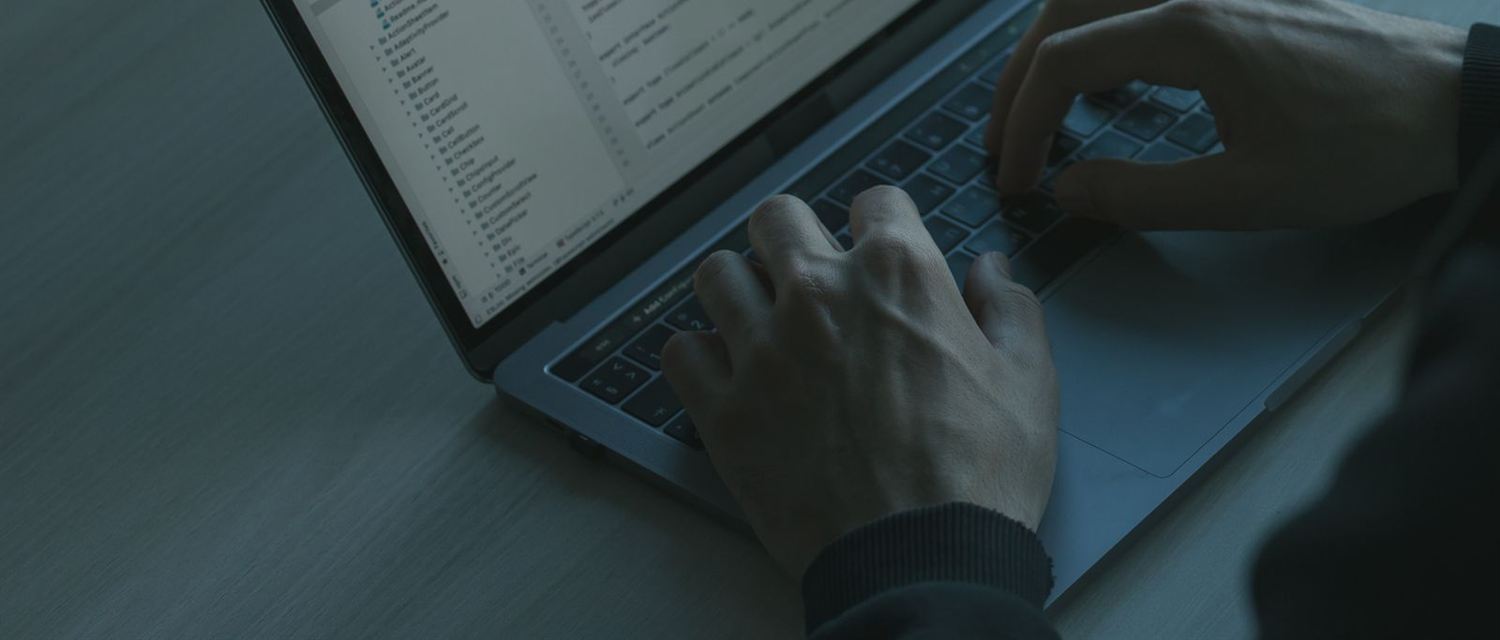 Mãos digitando num notebook com um editor de código aberto